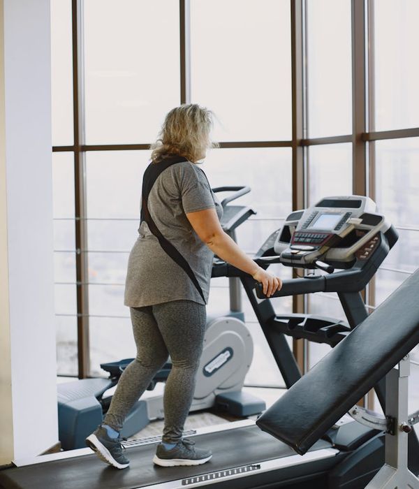 Person feeling energized and calm after a workout, looking out a window.